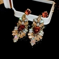 Close-up of sparkling amber teardrop earrings with champagne rhinestones on black background - 53# Silver Needle-Colorful Rhinestone-Amber Retro Palace