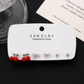 Three-pair earring set featuring red cherries, silver bows, and round zircon studs - White K (6696)