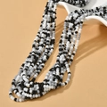 Detail of 3mm matte beaded necklaces in mixed black, white, and grey colors on a curved stand - Black and White