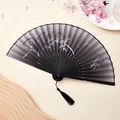 Classic folding fan with black bamboo pattern and dark wood ribs with elegant black tassel - Ink Orchid