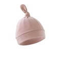 Detail shot of a soft pink cotton newborn infant hat with top knot design and folded rim - Taro