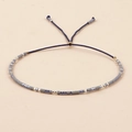 Detail of handmade beaded friendship bracelet with gray and blue seed beads and adjustable cord - Blue Grey Mixed
