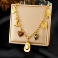 Goldenes Bettelarmband mit Western-Anhängern auf schwarzem Seidenhintergrund - Western Cowboy Stil mit mehreren Anhängern (N3887)
