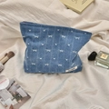 Detail of blue denim cosmetic bag with white bow embroidery and smooth metal zipper closure - Bowknot Style / Dark Blue