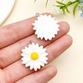 White and yellow resin daisy charms for DIY jewelry making with silver ring attachments - White