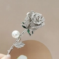 Dettaglio della spilla a rosa argentata con cristalli, perla bianca e smalto verde - Rosa-Argento