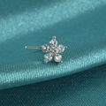 Macro shot of silver flower nose stud with clear zircon on turquoise silk background - Style A / White Zirconia