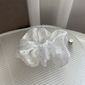 Detail of white satin scrunchie with silver rhinestone embellishments on textured base - White