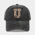 Detail of washed black baseball cap with leopard print letter U patch and pink stitching - Letter U