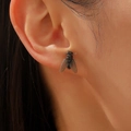 Macro di orecchini creativi a forma di mosca 3D con ali glitterate indossati - Nero