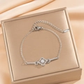 Pulsera de trébol plateada con circonitas brillantes sobre fondo de seda color champán - Plateado (S1125)