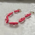 Detail of chunky acrylic chain with rose red and frosted links on white faux fur - Frosted Rose Red
