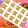 Detailed view of golden butterfly acrylic crystal stickers in a decorative pink setting - Gold Butterfly Pearl