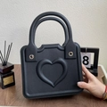 Minimalist black EVA beach tote bag featuring a 3D heart pattern and silver metal rivets - Black