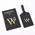 Detail of black passport holder and luggage tag with gold letter W and camera icon - Black Letter W