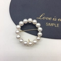 Detail of 14 natural freshwater pearls arranged in a circular gold brooch on leather - Clean Pearl Circle Gold