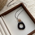 Détail du collier pendentif ovale en bois et résine sur un plateau en velours - 3# Collier-Café-Carré