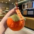 Macro shot of plush persimmon keychain with Good Luck tag and orange metal clasp - Persimmon Forever Love