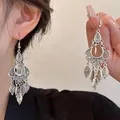 Detaillierte Nahaufnahme von Boho-Silberohrringen mit filigranen Mustern und Tropfenanhängern - Stil 3 Haken Silber Wassertropfen