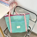 Dettaglio della borsa da spiaggia in rete verde menta con manici rosa e tasca esterna - Verde
