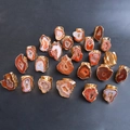 Macro detail of natural agate stone rings with gold-plated edges on dark background - Orange Red