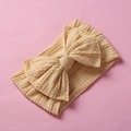 Close-up detail of a soft yellow cable-knit baby headband with a large bow design - Light Yellow