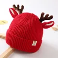 Close-up of red knit baby hat featuring plush reindeer antlers and a stitched baby label - Hat - Red