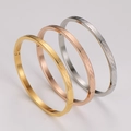 Close-up of tricolor stainless steel bangles with etched wave pattern and side hinge closure - Steel+Gold+Rose Gold