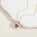 Dettaglio di un ciondolo a cuore dorato con pietra rossa e pavé di cristalli su base marmo - Zirconia Rossa (XL2601-2)