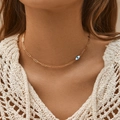 Gold paperclip chain necklace featuring a blue evil eye pendant on a fashion model - 18K Gold