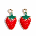 Macro view of gold-plated red strawberry charms with green leaves for DIY jewelry making - Strawberry