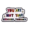 Close-up of You Are Not Your Anxious Thoughts enamel pin with colorful letters - YOU ARE NOT YOUR ANXIOUS THOUGHTS