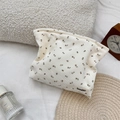Detail van een crèmekleurige corduroy make-uptas met bruine bloemenpatronen en textuur - Beige