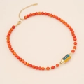 Detail view of retro beaded evil eye necklace with red orange beads and gold metal clasp - Orange Malachite Style (AND/Blue Orange Texture)