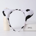 Detail of plush cow print animal ear headband with black and white spots for cosplay - Cow