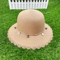 Detail view of wide-brim straw hat with gray beads and shell charms on green lawn - M (56-58cm) / Khaki Cloche Style
