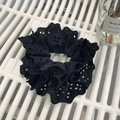 Detailed view of elegant black lace scrunchie with intricate floral eyelet embroidery - Black