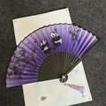 Macro detail of a purple hand fan featuring painted pandas, bamboo and a silk tassel - Panda Bamboo Purple - Black Handle