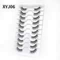 Detailed macro shot of 10 pairs of XYJ06 cat-eye wispy false eyelashes in a white tray - Curled Voluminous Style (XYJ06) / 10 Pairs Set