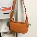 Vibrant orange nylon messenger bag with adjustable green strap and spacious compartments - Orange