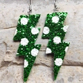 Dettaglio degli orecchini a fulmine verdi glitterati con pois bianchi su fondo pietra - Verde a Pois Glitter