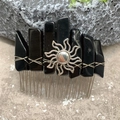 Macro detail of obsidian crystal hair comb with silver sun charm on stone surface - Obsidian Silver Wire Silver Sun