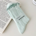 Minzgrüne Socken mit Rüschensaum und vertikalen Streifen in gemütlicher Optik - Hellgrün