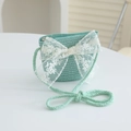 Detail of mint green straw bag with delicate white lace bow and woven strap - 52cm (3-6 Years) / Bag / Blue
