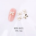 Detalle de dijes para uñas de lazo de 9x6,5mm con perlas y acabado dorado sobre blanco - Lazo Blanco Borde Dorado con Perla(8421)