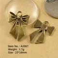 Zinc alloy bow pendants in vintage bronze finish with detailed size 23x16mm macro view - A2067-23*16MM