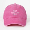 Nahaufnahme der rosa gewaschenen Baumwollkappe mit weißer Don't Forget to Smile Stickerei - Fuchsia