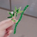 Detail of green bamboo hair claw clip with white pearl accent in hand for styling - K68 Green Bamboo