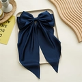 Détail d'un nœud papillon en satin bleu marine avec de longs rubans sur un plateau - Bleu marine