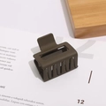 Detail view of square matte olive green hair claw clip with cutout design on wood - 5cm / Brown